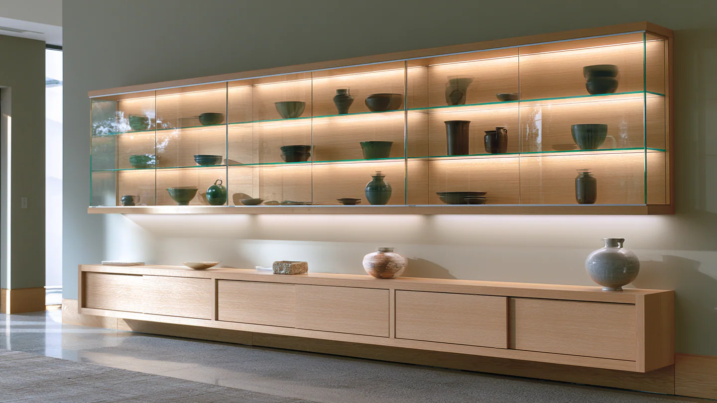 A wood and glass collection display wall, shown as a wide room view