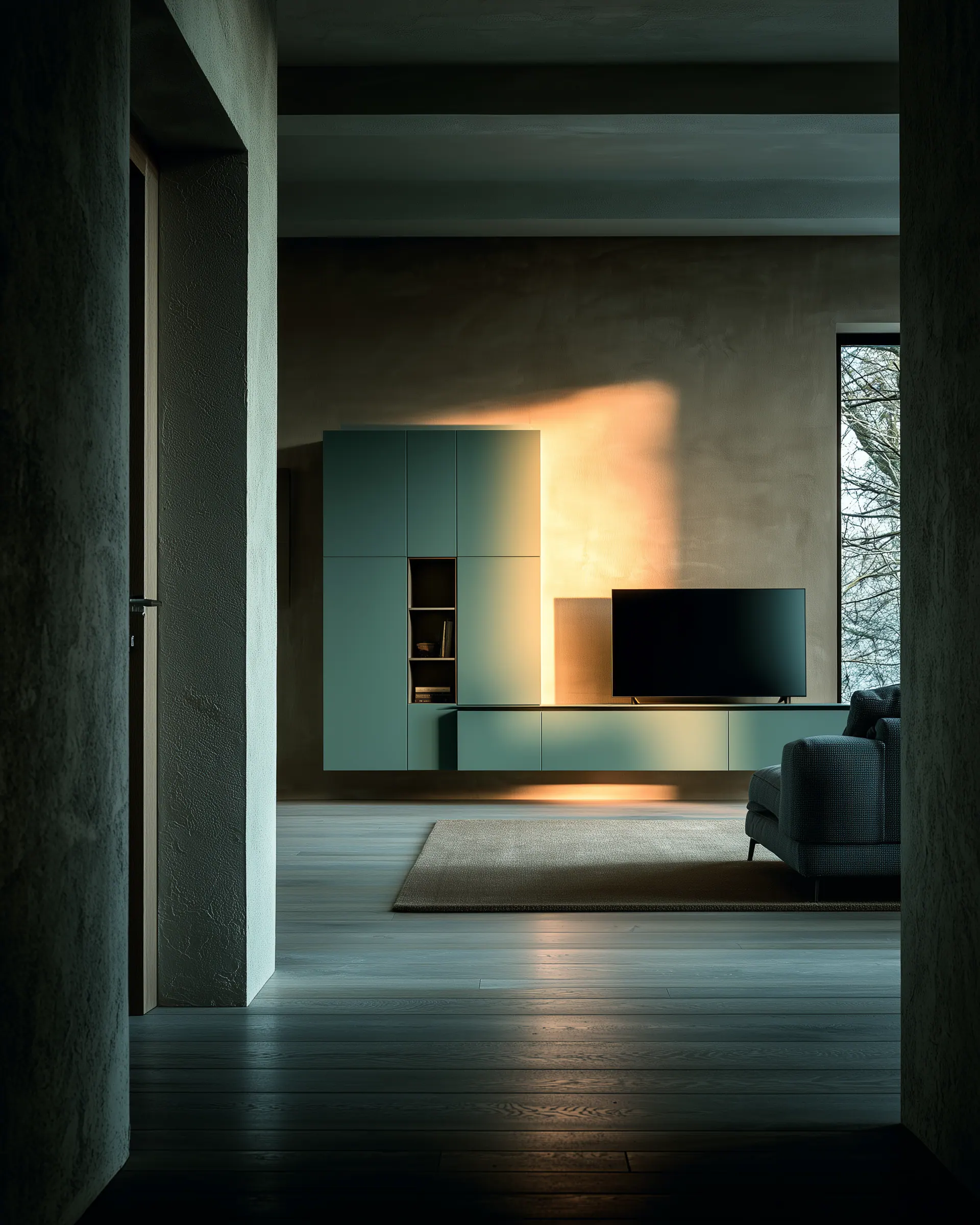 Deep green aluminum media console and tower cabinet seen from a shadowed adjoining room