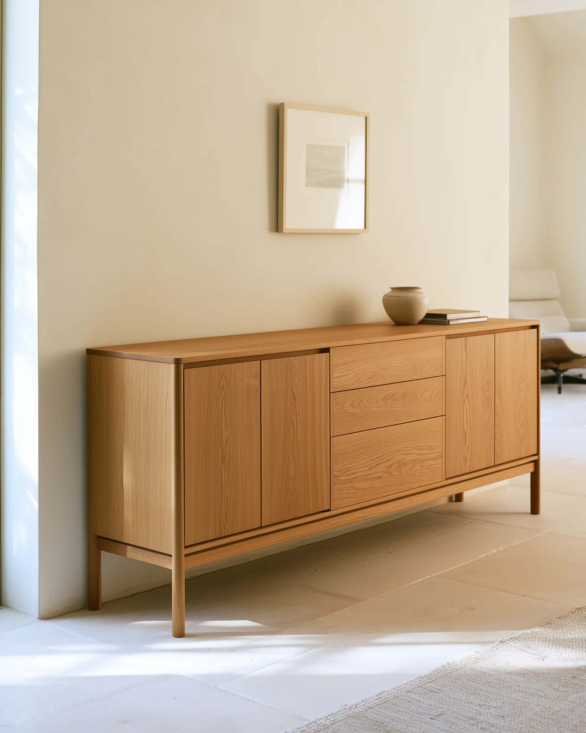 Light wood living room sideboard with framed doors and drawers in a bright neutral interior